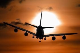 Airplane flying into the sunset
